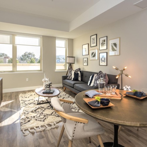 a living room with a tv, couch, tables and chairs